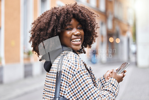 Image of Phone, happy and portrait of a black woman in the city networking on social media, mobile app or internet. Happiness, smile and African female typing a message on a cellphone while walking in town.