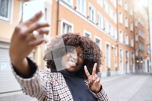 Image of Selfie, peace hand sign and black woman in a city on travel with a phone and happiness outdoor. Urban street, vacation and smile of a young person on social media for holiday traveling feeling relax