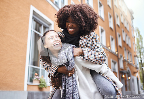 Image of Girl friends, laughing and city travel adventure of young people with a piggyback and happiness. Freedom, diversity and women smile outdoor feeling happy on a walk on a urban holiday together