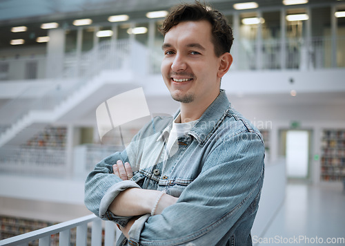 Image of College, knowledge and portrait of a man in a library for studying or learning for education. University, confidence and male student standing with crossed arms in a book store to work on school exam