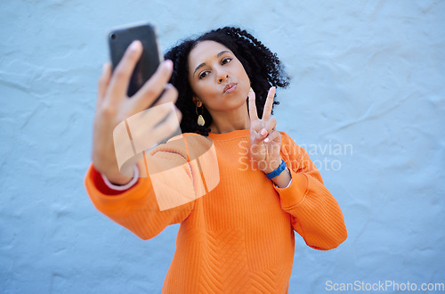 Image of Selfie, pose and woman by a wall in the city while on a travel holiday or weekend trip in Mexico. Freedom, peace sign and female taking a picture with a hand gesture in a urban town on a vacation.