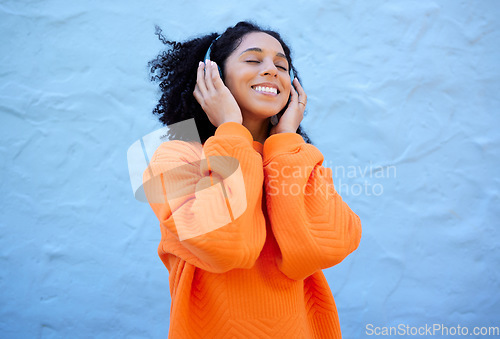 Image of Happiness, black woman and headphones for streaming, music and cheerful on blue studio background. African American female, lady or headset for audio, sounds and podcast with girl, smile and backdrop