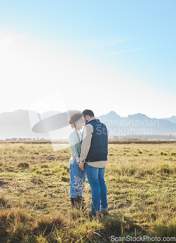 Image of Love, interracial and couple on countryside vacation, holding hands and joyful outside with romantic view. Romance, happy man and black woman on field, holiday and weekend break, happiness or support