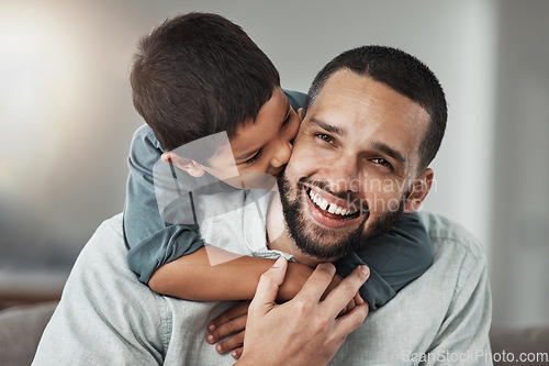 Image of Happy, love and child kissing his father while relaxing in the living room at their family home. Happiness, smile and portrait of a young man hugging and bonding with boy kid with care and in house.