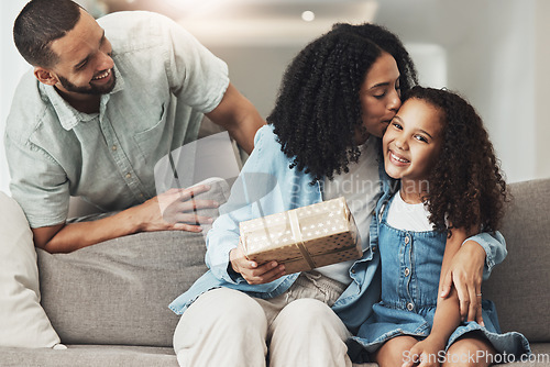 Image of Birthday, kiss and child with gift from parents to celebrate a special occasion, achievement or event. Affection, gratitude and mom kissing a child while giving a present from dad for celebration