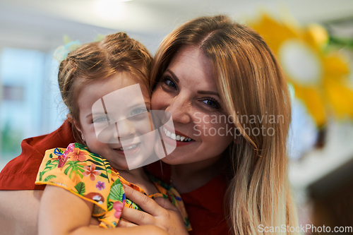Image of A cute little girl kissing and hugs her mother in preschool