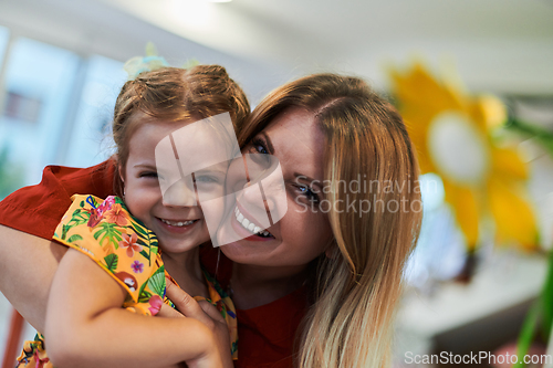 Image of A cute little girl kissing and hugs her mother in preschool