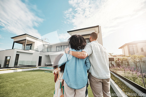 Image of Love, new home and family standing in their backyard looking at their property or luxury real estate. Embrace, mortgage and parents with their children on grass at their house or mansion in Canada.