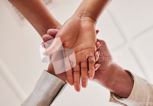 Image of People, hands together and unity below in trust for community, agreement or teamwork at the office. Group piling hand for team collaboration, support or coordination for corporate goals in solidarity