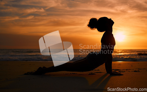 Image of Sunset yoga, fitness and silhouette of a woman at the beach for mindfulness training at night. Meditation, zen and girl stretching for a pilates pose at the sea in the evening for spiritual exercise