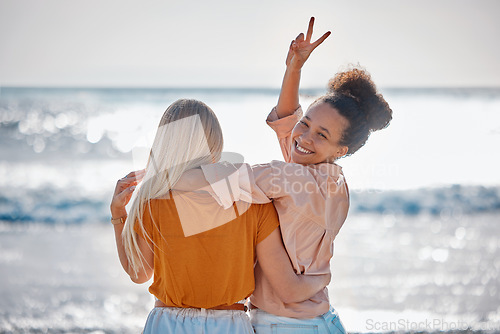 Image of Hug, peace sign and portrait of friends at the beach for summer, holiday and bonding in Miami. Travel, freedom and back of women with hand emoji for carefree energy, playful and happy by the sea