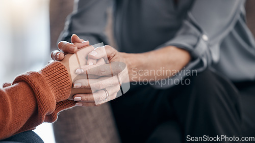 Image of Woman, holding hands and closeup for therapy, support and consultation for mental health problem on sofa. Women, helping hand and psychologist with talk, advice and care for anxiety with depression