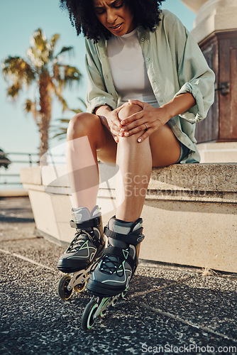 Image of Knee pain, roller skater injury and woman in city after accident or fall outdoors. Sports, training and black female with fibromyalgia, inflammation or painful leg after skating practice on street.