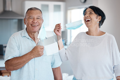 Image of Covid, mask remove and senior couple portrait with a smile at home in a kitchen. Happy man, mature and marriage of a grandparents in a house laughing with love and care in a household to relax
