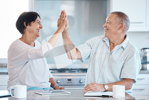 Image of High five, tablet and senior couple in kitchen happy for success in online banking, ecommerce and internet. Love, retirement and elderly man and woman celebrate with digital tech, notebook and smile