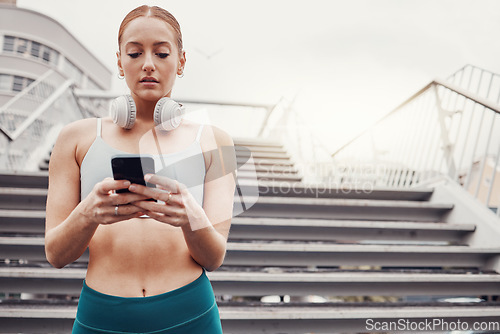 Image of City, workout and woman with smartphone typing, communication, 5g and headphones after exercise. Health, training and personal trainer on phone texting, fitness app to connect or network in sports.