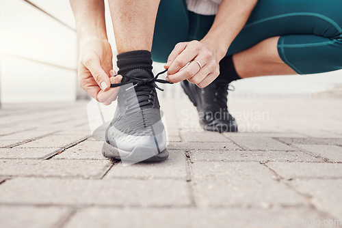 Image of Shoes, runner and woman getting ready for training, exercise or running in sports sneakers, fashion and urban street. Feet of athlete or person tying her laces for cardio, fitness or workout outdoor