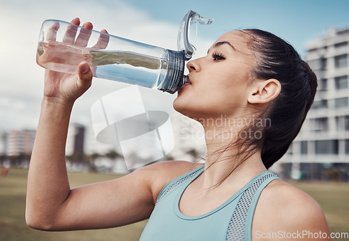 Image of Fitness, woman and drinking water in the city after running, exercise or cardio workout in Cape Town. Female runner with bottle and natural drink for thirst, hydration or aqua liquid for sports break
