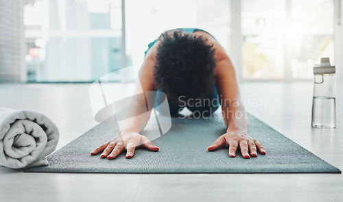 Image of Yoga, stretching and fitness of a black woman in a gym for zen, relax and chakra exercise. Pilates, peace and meditation training of an athlete in prayer pose on the floor feeling calm from stretch