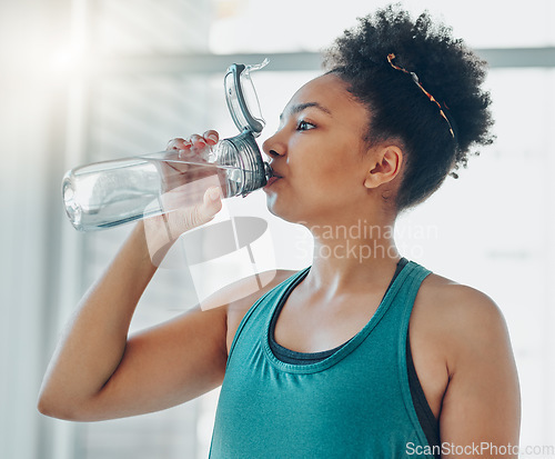 Image of Drinking water, black woman and fitness of a athlete in a gym after workout and sport. Hydration, drink and healthy young person in a wellness and health center with bottle for training and exercise