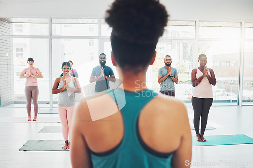 Image of Yoga class, instructor and meditation exercise with fitness people prayer hands for health and wellness. Diversity men and women in pilates studio for holistic workout or body balance with zen energy