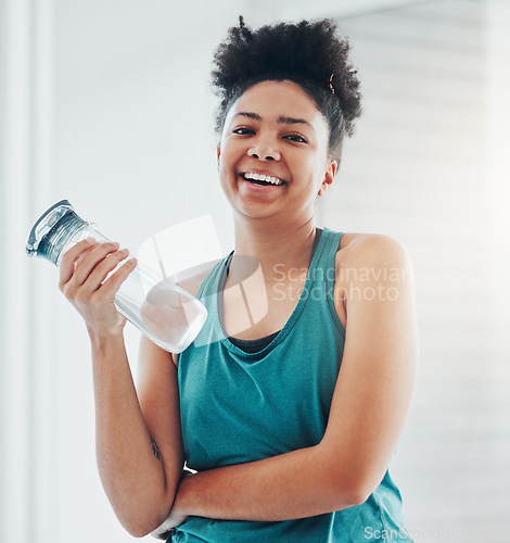 Image of Portrait, fitness and water with a sports black woman staying hydrated during her cardio or endurance workout. Exercise, training and wellness with a female athlete holding a bottle for hydration