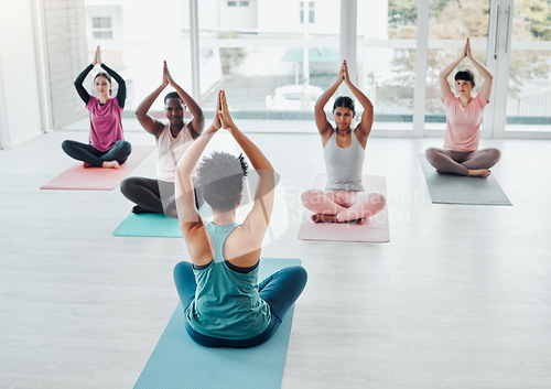 Image of Meditation, yoga class and diversity women exercise for fitness, peace and wellness. Group with instructor in health studio teaching holistic workout, mental health and balance with hands in prayer