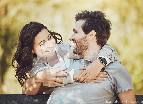 Image of Hug, love and couple on park bench, smile and having fun time together outdoors. Valentines day, romance relax and care of happy man and woman hugging, embrace and cuddle on romantic date outside.