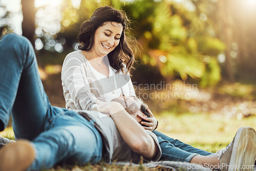 Image of Love, relax and couple at park, laughing at funny joke or comic comedy and having fun together outdoors. Valentines day, romance cuddle and care of man lying on lap of happy woman on romantic date.