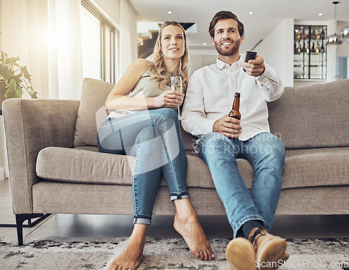 Image of Tv, couple and relax on sofa with alcohol streaming movie, film or video on valentines day. Champagne, beer or happy man and woman watching movies, online show or television and enjoying time in home