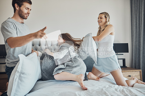 Image of Family in pillow fight, happiness and fun together at home, parents and child in bedroom, playful and bonding. .Man, woman and girl play game, funny and crazy with energy and love with quality time