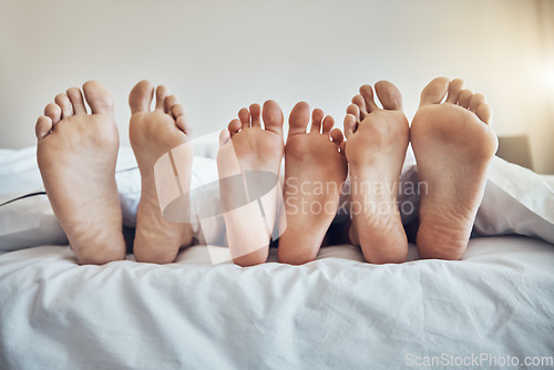 Image of Family feet, bed and together with kid, parents and sleeping on holiday for bonding, care and happiness. Bedroom, people and sleep with mom, dad and child on vacation to relax, break and hospitality