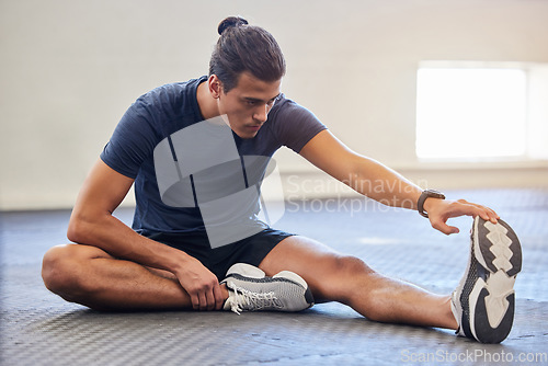 Image of Fitness, stretching legs and man with training, workout or running focus. wellness and muscle health on the floor. Sports athlete, runner or person with warm up in gym for exercise goals on ground