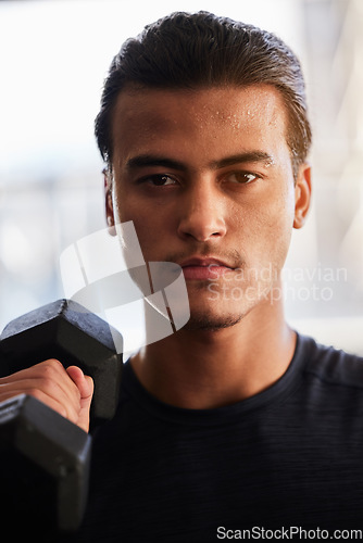 Image of Fitness, portrait or man with a dumbbell at gym training, exercise or workout for body goals or wellness. Motivation, sports or healthy athlete weightlifting for muscle growth isolated in studio