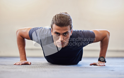 Image of Fitness, portrait or push up with man in gym training or exercising in a body workout for endurance. Healthy male, strong or powerful sports athlete focused on floor exercise challenge for wellness