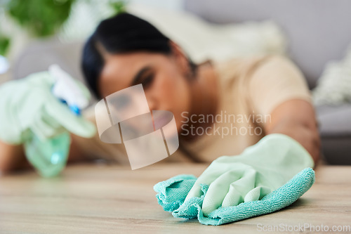 Image of Hand, cleaning and cloth with a woman housekeeper wiping a wooden furniture surface using disinfectant. Gloves, wipe and hygiene with a female cleaner in a home for housekeeping or sanitizing