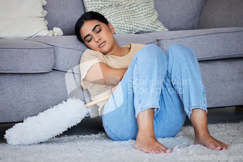 Image of Sleeping, tired woman cleaner and feather duster of a maid in a home tired on the living room floor. Sleep, rest and burnout of a house worker on the job in a house working on hygiene and dusting