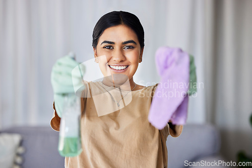 Image of Woman, portrait and cleaning with product, cloth and smile in home living room for wellness, hygiene or stop bacteria. Happy cleaner, bottle and spray for clean, safe or dirt free house for happiness