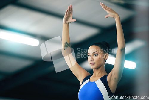 Image of Sports, gymnastics and woman gymnast practicing for a competition or sport training in a gym. Fitness, athlete and female acrobat in a posture for a balance, flexibility or agility exercise in arena.