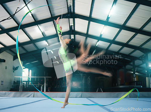 Image of Gymnastics, motion blur and ribbon dance with a woman in a gym training for the olympics competition. Fitness, art and rhythmic dancing with female gymnast in a studio for a workout or exercise