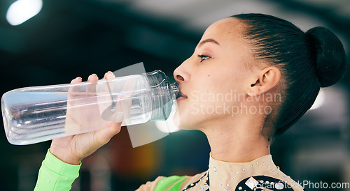 Image of Woman drinking water, bottle and gymnast in gym, competition with athlete, hydration and health with fitness. Exercise, face profile and active with gymnastics, wellness and healthy with sports