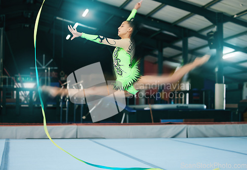 Image of Gymnastics, woman and jump with ribbon and motion blur, sport in gym with action and speed for fitness. Athlete, moving with rhythmic gymnast, flexibility and pose with sports and splits in air