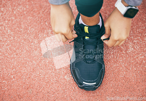 Image of Hands, top view and woman tie shoes at running track, stadium or arena outdoors. Sports, training and black female athlete tying sneaker lace, getting ready and preparing for exercise, workout or run