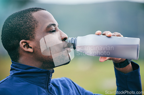 Image of Fitness, health and side profile of black man drinking water to hydrate after running, exercise and workout. Healthy, sports and African athlete with a drink after training and cardio in Germany