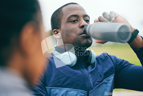 Image of Break, fitness and black man drinking water after a race, training and sports at a stadium in Morocco. Health, relax and African athlete with a drink to hydrate after a workout, running and exercise