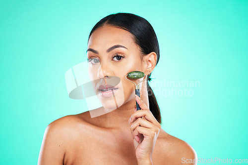 Image of Portrait, beauty and face massage with roller by woman in studio for wellness, grooming or cosmetic skincare. Facial and jade tool by girl model relax with skin product and isolated on background