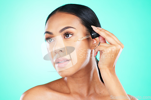 Image of Skincare, oil and black woman in studio for beauty, wellness or cosmetics on blue background. Face, serum and girl with facial product for skin, anti aging or collagen, retinol or hyaluronic acid