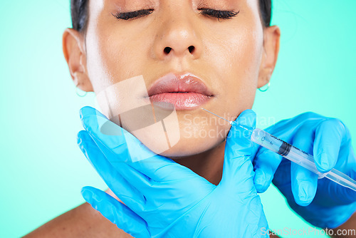 Image of Woman, face and hands with syringe for plastic surgery, lip implants or botox isolated on a studio background. Hand of doctor with needle injecting filler on female lips for facial cosmetic treatment