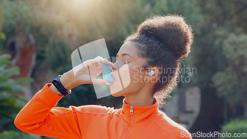 Image of Young black woman athlete using asthma pump after his daily workout routine outside. Dedicated black women taking care of her health and wellness. Endorsing a healthy lifestyle by exercising and taki