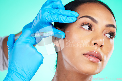 Image of Skincare, black woman and injection for cosmetics, treatment and girl on blue studio background. Plastic surgery, African American female or confident lady with needle for soft, gloves or smooth skin